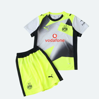 Kit infantil Borussia Dortmund II 25/26 com camiseta branca, preta e amarela neon, e shorts amarelo neon e preto. Escudos BVB e logos Puma e Vodafone visíveis.