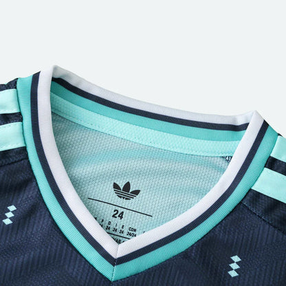 Detalhe do colarinho em V de uma camisa de futebol Adidas com listras azuis e brancas.