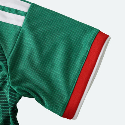 Detalhe da manga de uma camisa verde, com as cores verde, vermelho e branco no acabamento.
