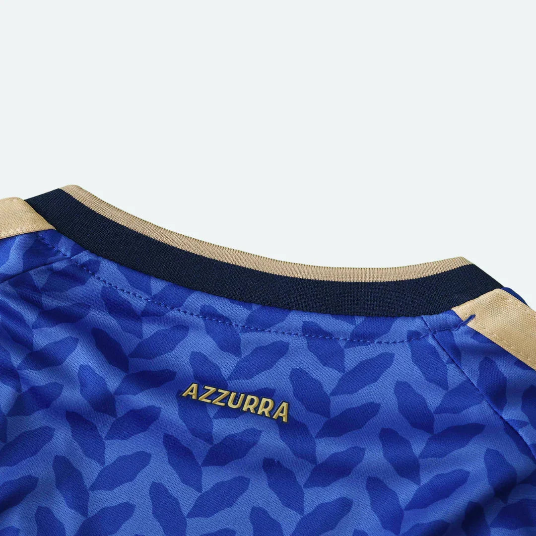Detalhe da gola interna de camisa azul com a palavra AZZURRA dourada e padrão de folhas.