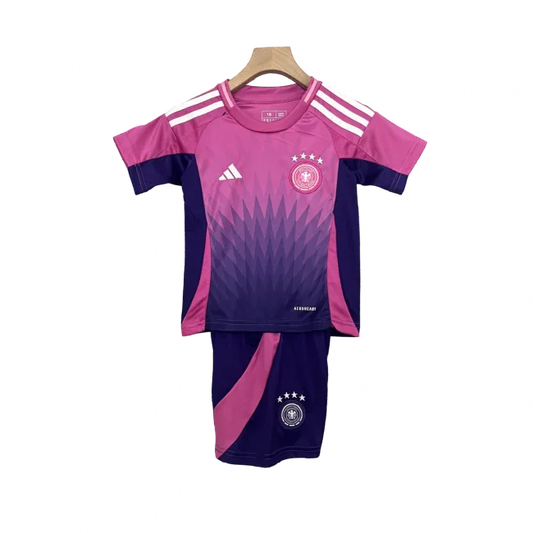 Kit de futebol infantil da Alemanha II 24/25. Camisa rosa e roxa com listras brancas e shorts roxos com detalhe rosa, ambos com o escudo da Alemanha.