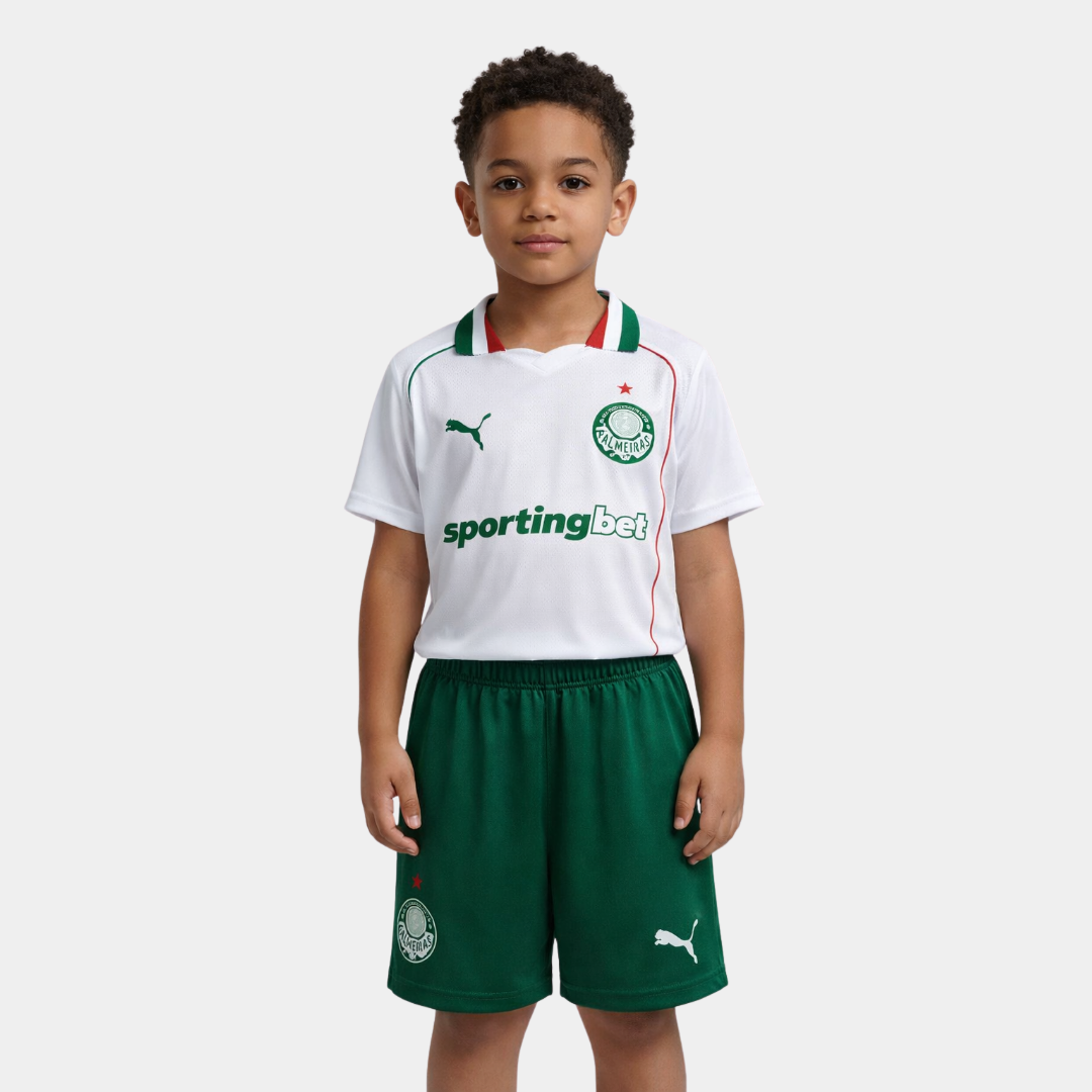 Menino vestindo o kit infantil do Palmeiras, com camisa branca, detalhes em verde e vermelho, e calção verde