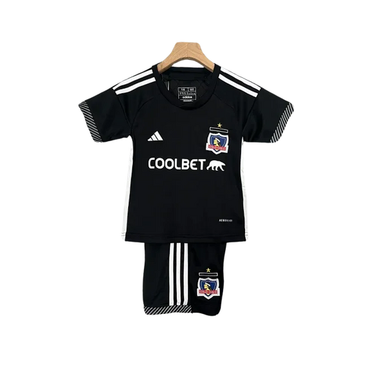 Kit infantil Colo Colo II 24/25 preto. Camisa preta com listras e logos brancos, escudo Colo Colo, e shorts pretos com listras brancas.