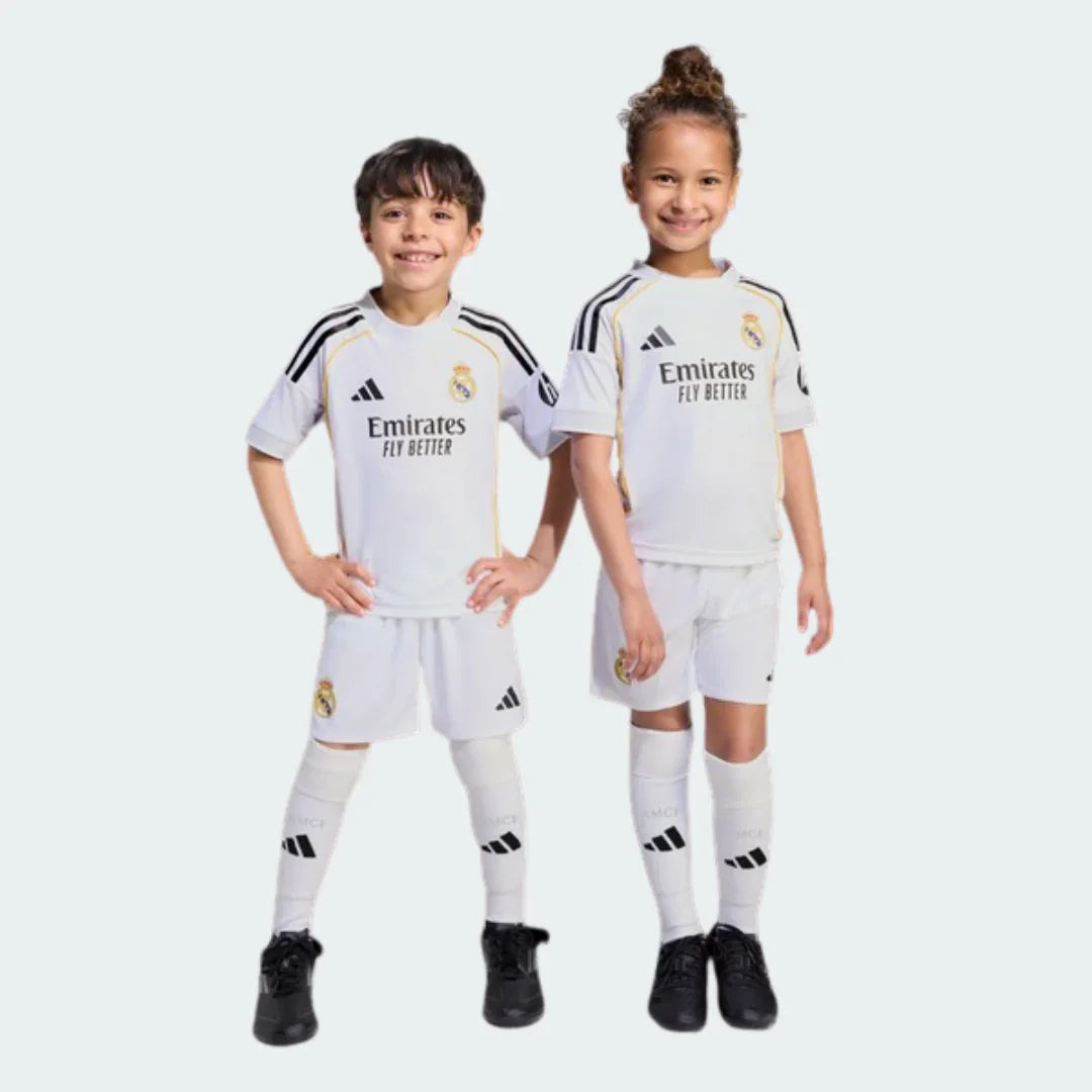 Kit oficial infantil Real Madrid Mini Mantos. Camisa, shorts e meias. Crianças sorrindo com o uniforme completo