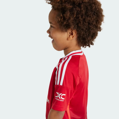 Mini Mantos Bayern infantil oficial. Kit camisa vermelha. Criança sorrindo com uniforme de futebol