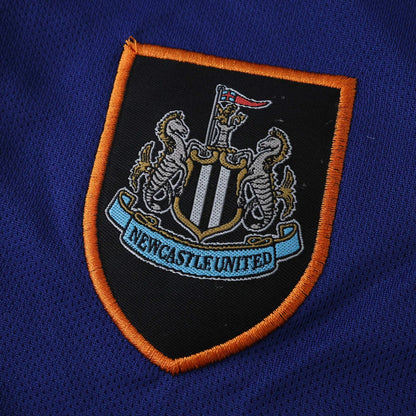 Mini Mantos: Kit camisa infantil oficial Newcastle United. Escudo bordado do time em detalhe na camisa azul