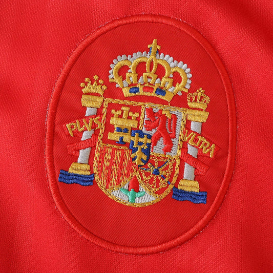Camisa Espanha infantil oficial kit bordado Mini Mantos com brasão detalhado em tecido vermelho