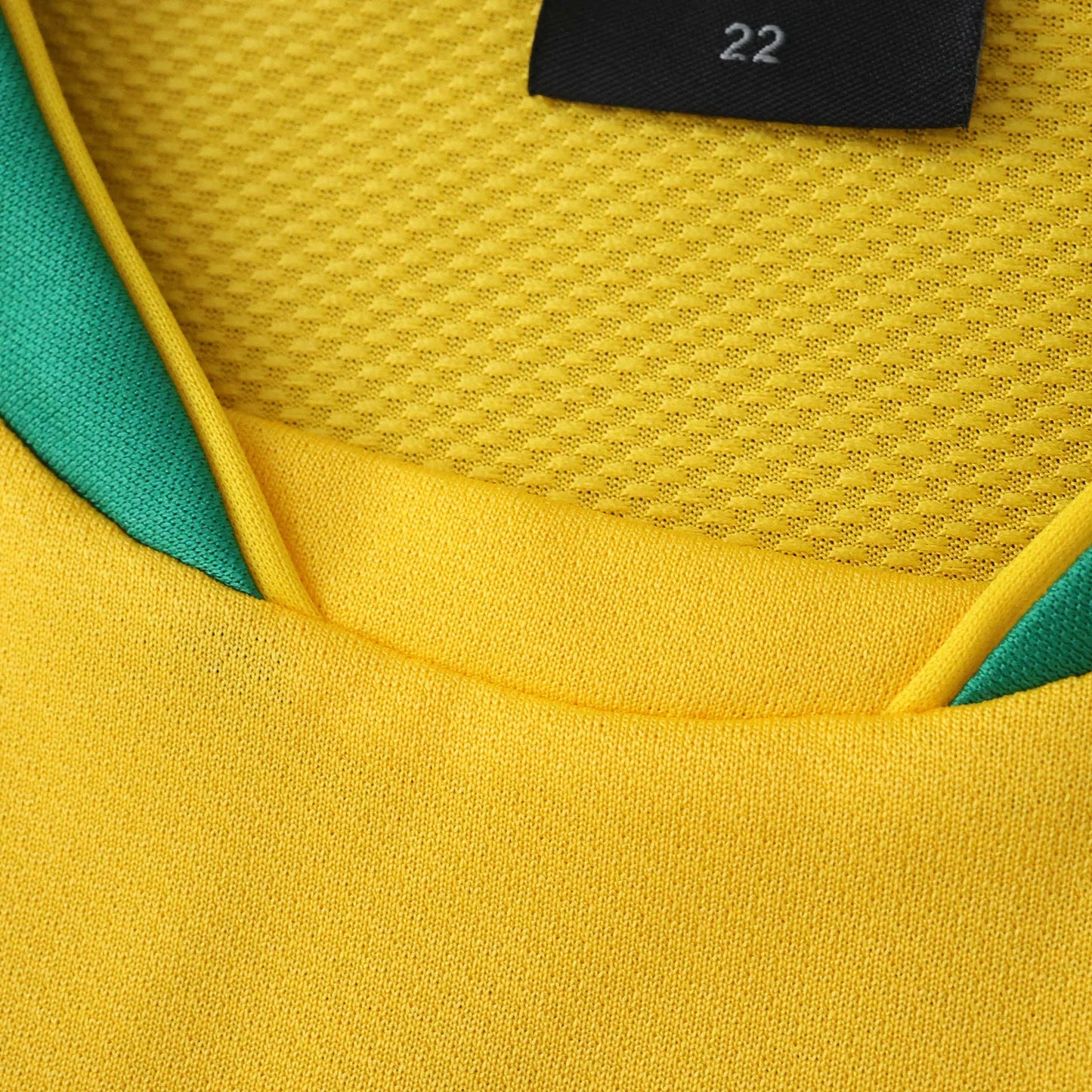 Camisa oficial Brasil Mini Mantos kit infantil, amarela e verde. Detalhe da gola, tecido furadinho e malha