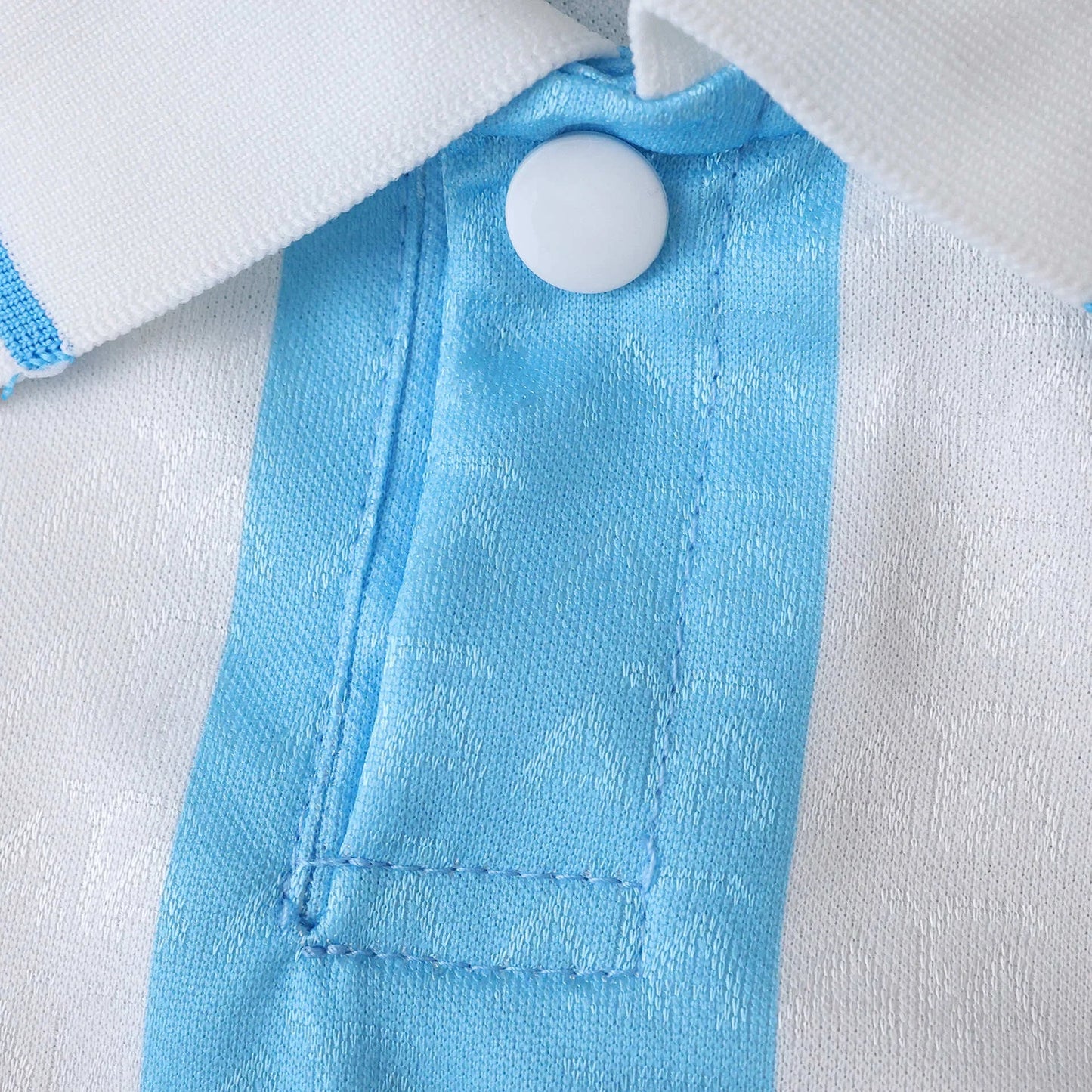 Close-up da gola e peito de uma camisa listrada verticalmente em branco e azul claro. Detalhe de botão branco e textura do tecido.