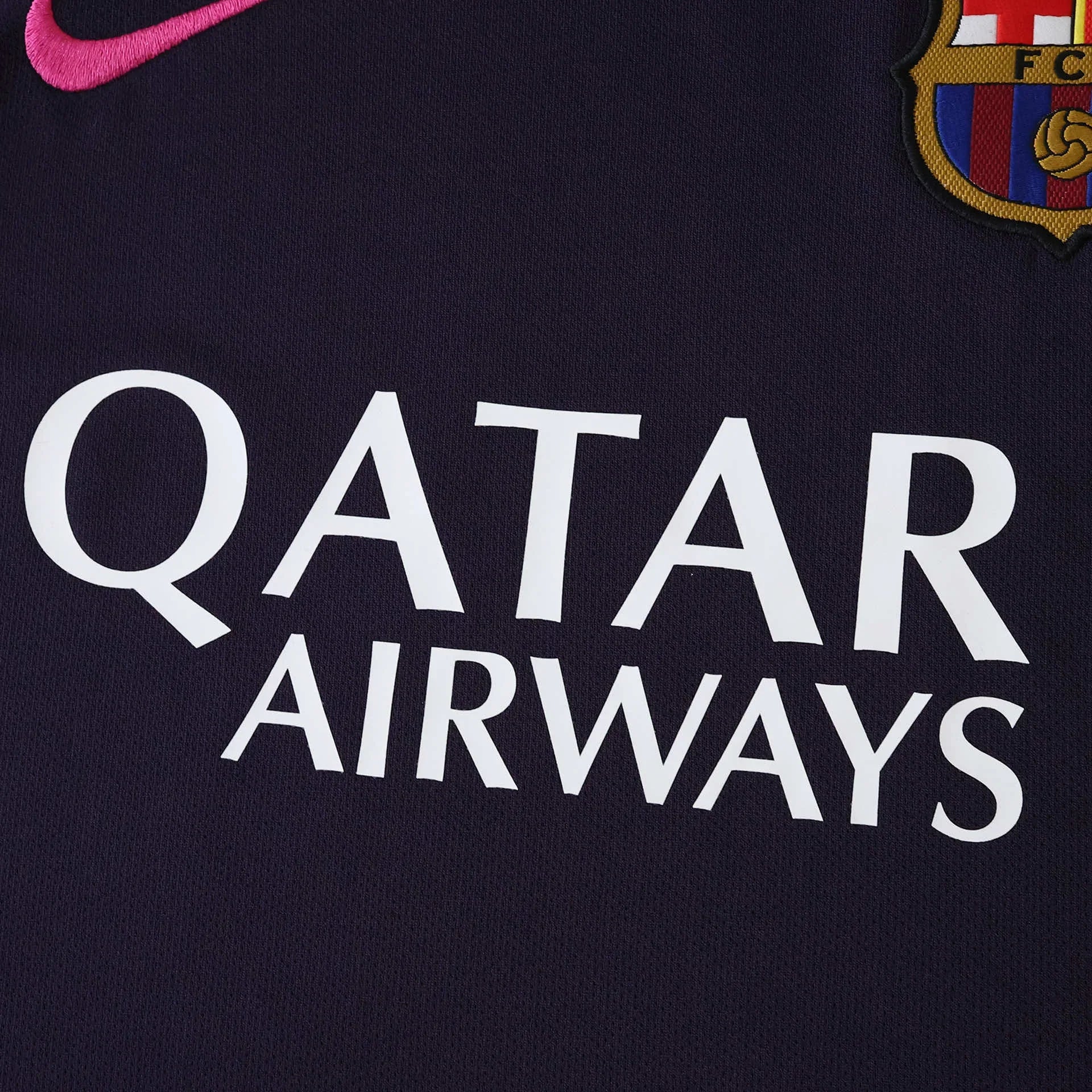 Foto em close de camisa de futebol roxa escura com logo Nike rosa, escudo bordado e patrocinador QATAR AIRWAYS branco.