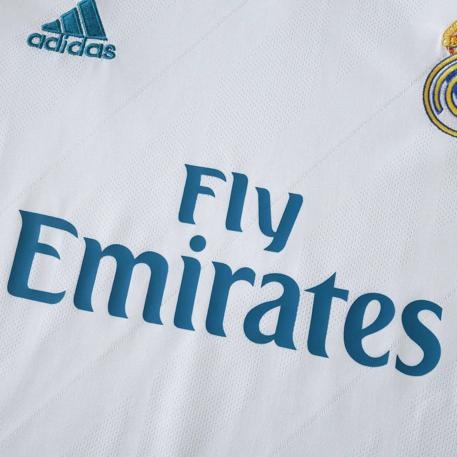 Camisa Real Madrid infantil oficial. Kit Mini Mantos. Detalhe da textura, logos Adidas e Fly Emirates e escudo