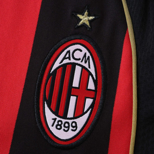 Camisa AC Milan infantil oficial kit Mini Mantos. Detalhe do escudo e estrela na camisa listrada vermelha e preta
