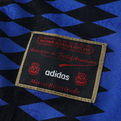 Tag oficial da camisa kit Argentina infantil adidas Mini Mantos, cores azul e preta