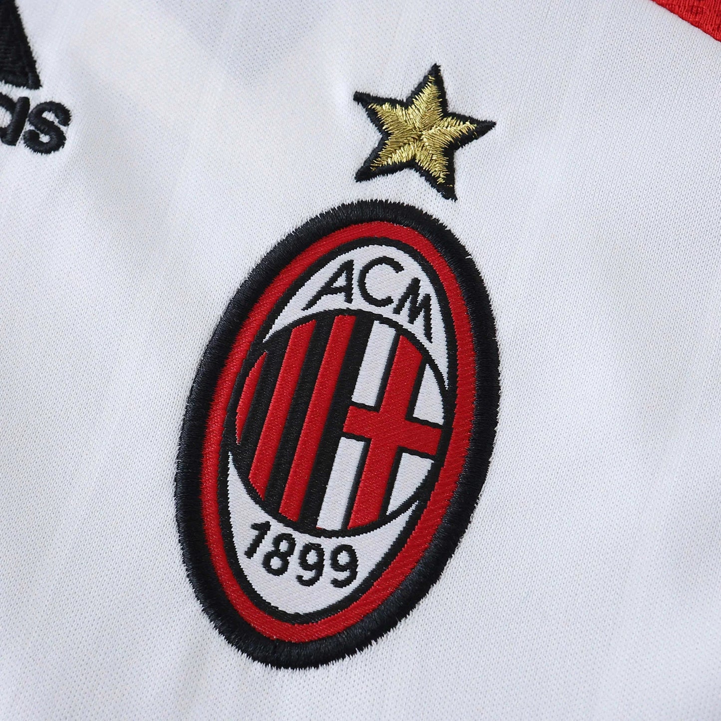 Camisa infantil oficial AC Milan, kit Mini Mantos. Detalhe do escudo