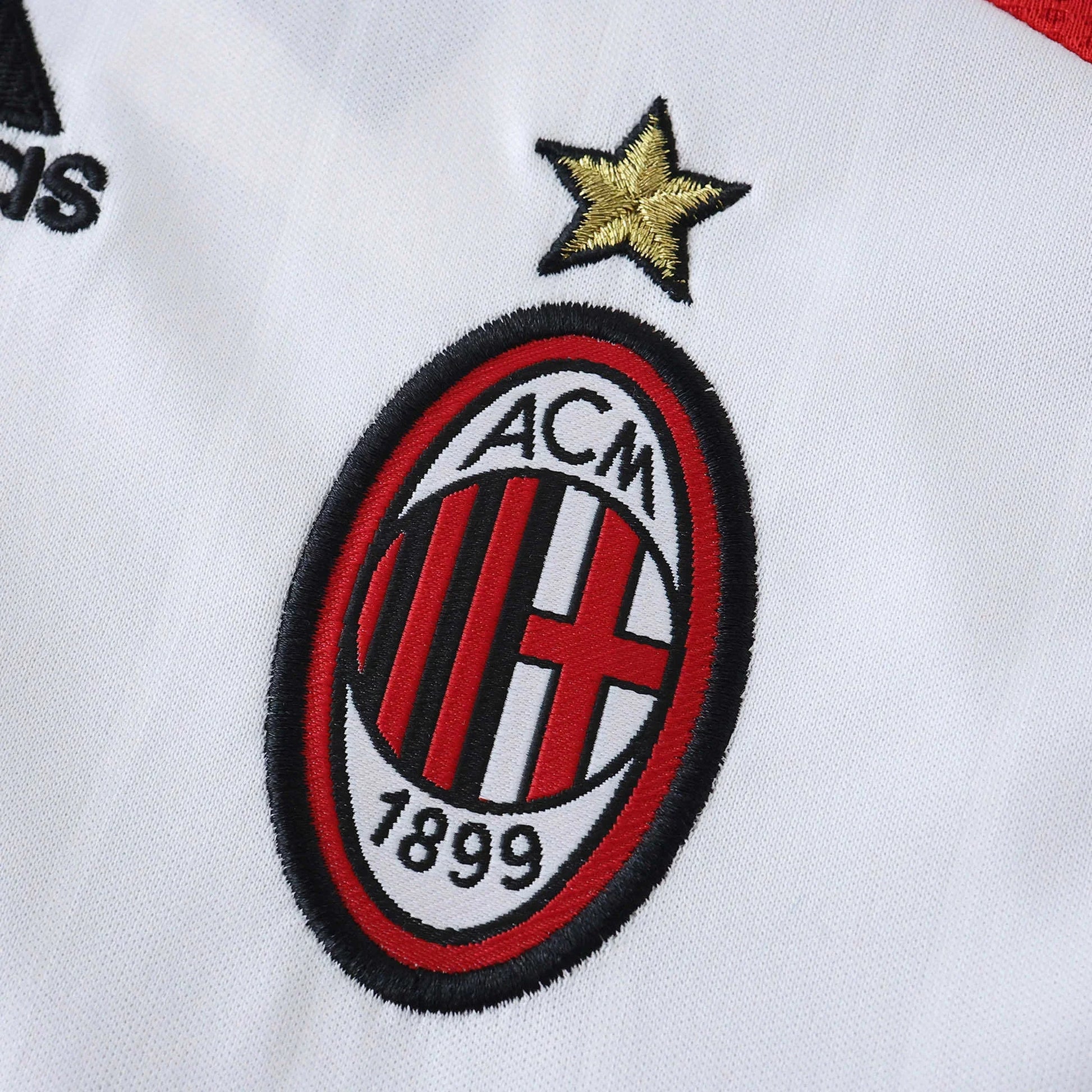 Camisa infantil oficial AC Milan, kit Mini Mantos. Detalhe do escudo