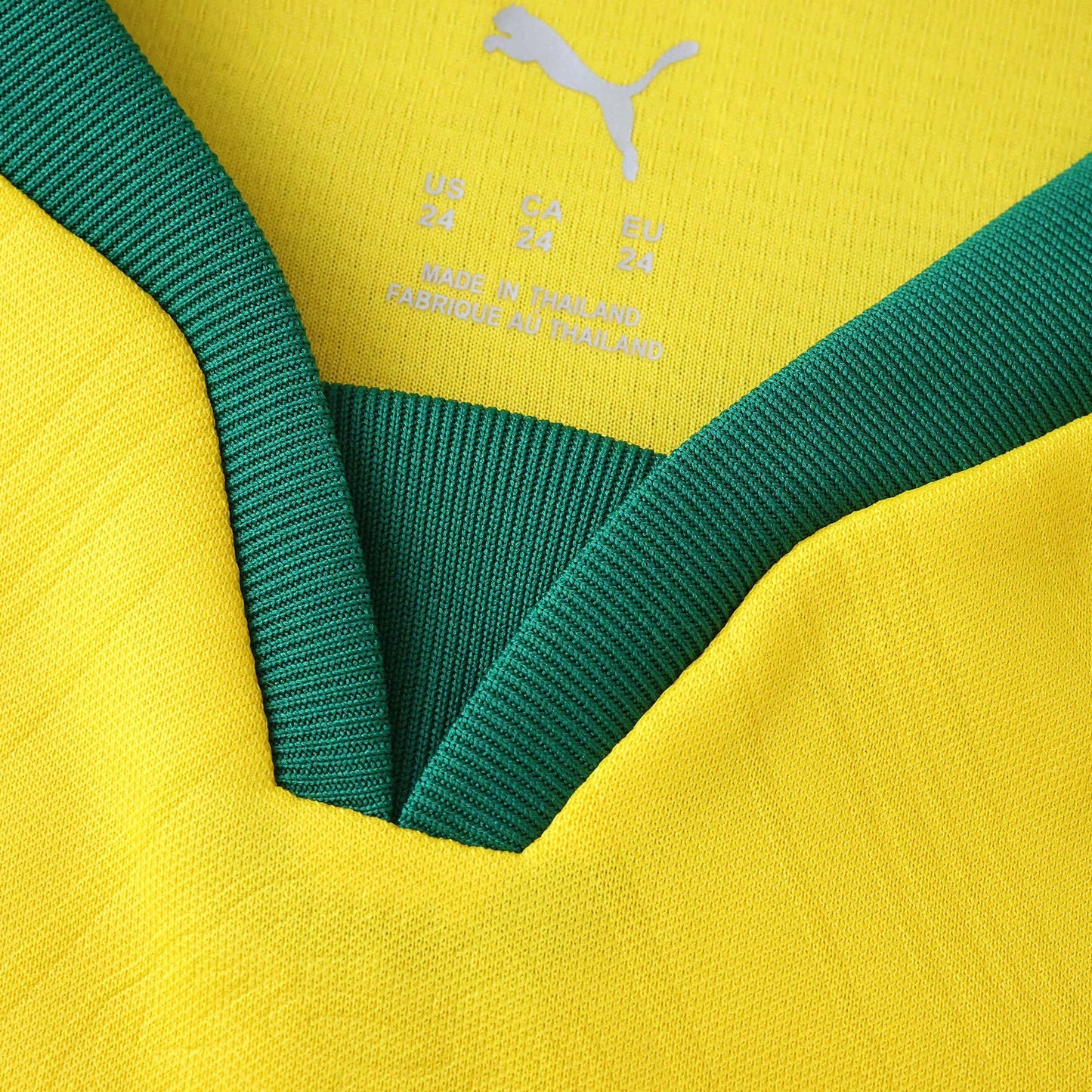Camisa infantil Puma amarela e verde, close-up do colarinho e etiqueta interna com logo Puma e informações de tamanho.
