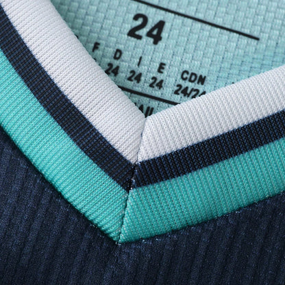 Close-up da gola V de um uniforme esportivo em tecido texturizado, com etiqueta de tamanho visível.