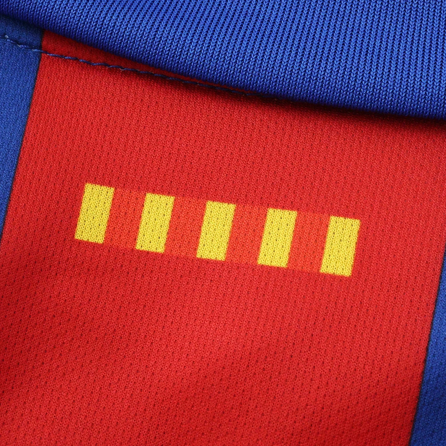 Close-up de tecido esportivo vermelho e azul com costura. A parte vermelha tem cinco barras retangulares amarelas e textura de malha.