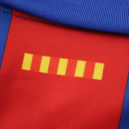 Close-up de tecido esportivo vermelho e azul com costura. A parte vermelha tem cinco barras retangulares amarelas e textura de malha.