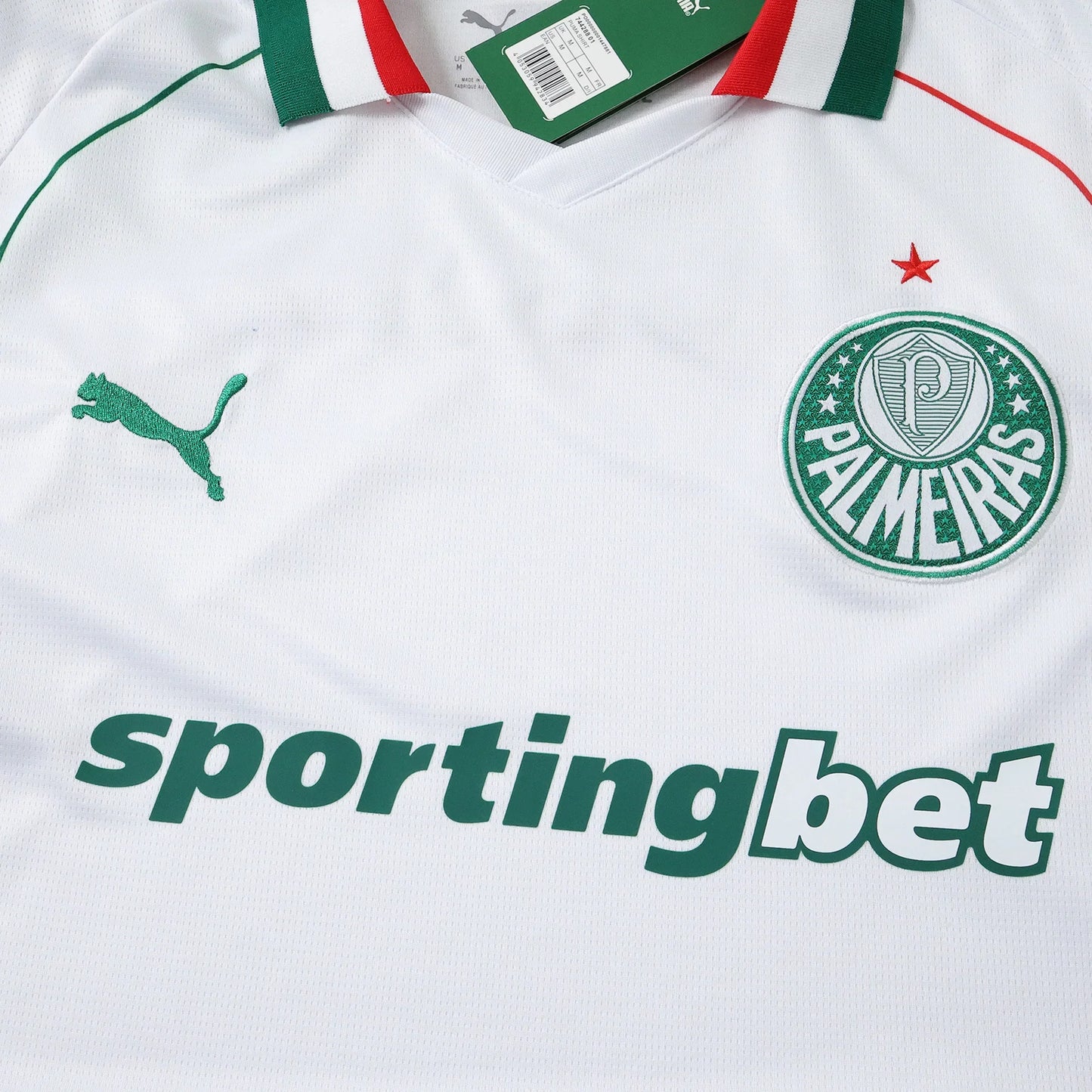 Camisa de futebol branca com gola listrada verde, branca e vermelha, logo Puma verde, escudo Palmeiras e patrocínio Sportingbet.