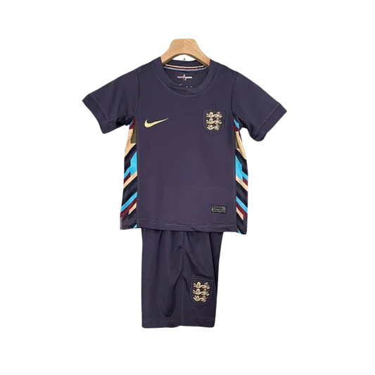 Kit infantil de futebol Inglaterra II 24/25, camisa e shorts roxo escuro com detalhes dourados e listras coloridas nas laterais.