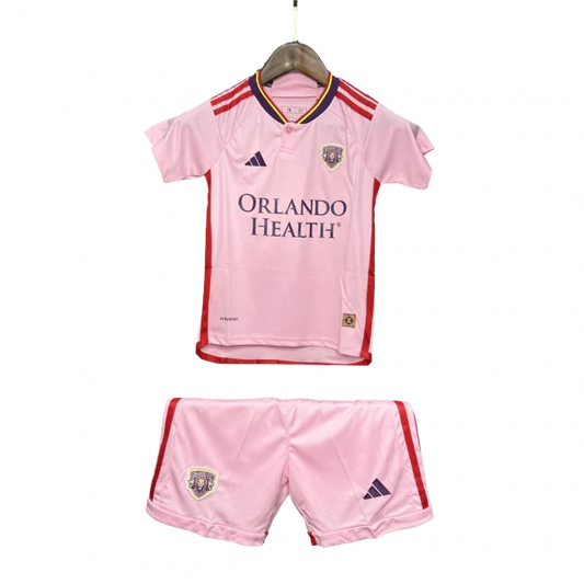 Kit infantil Orlando City II 24/25 rosa, com camisa e shorts. Camisa com escudo do time, logo Adidas e patrocínio Orlando Health.