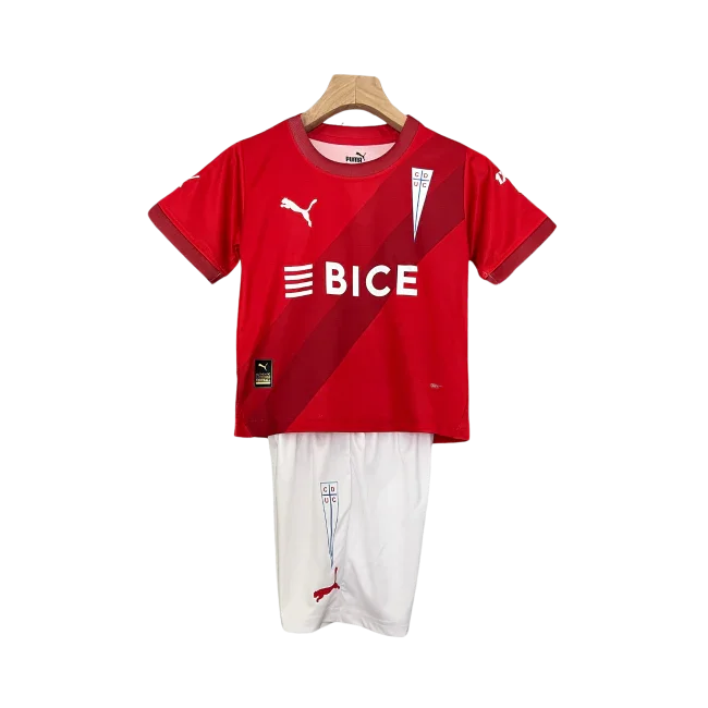 Kit infantil Universidad Católica II 24/25 vermelho e branco, com camisa vermelha, listras diagonais e shorts brancos, escudo e logos Puma e BICE.