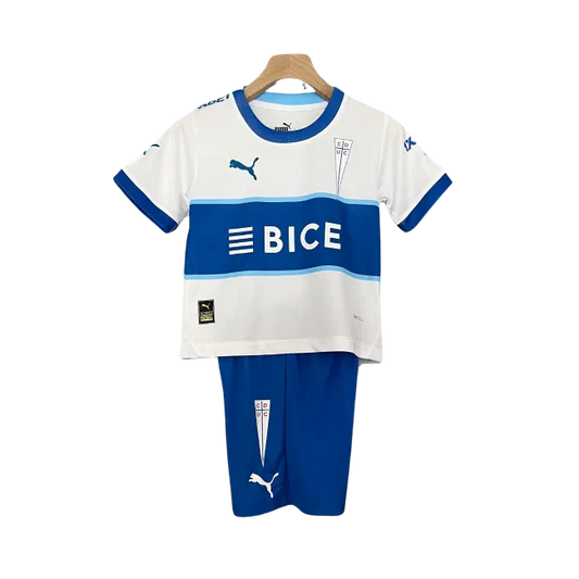 Kit infantil Universidad Católica 24/25. Camisa branca com listras azuis horizontais, logo BICE e escudo do clube. Short azul com escudo.