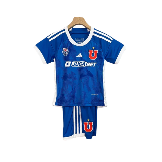 Kit infantil completo da Universidade do Chile, camisa e shorts em tons de azul e branco, com o emblema U e o logo Adidas, pendurado.